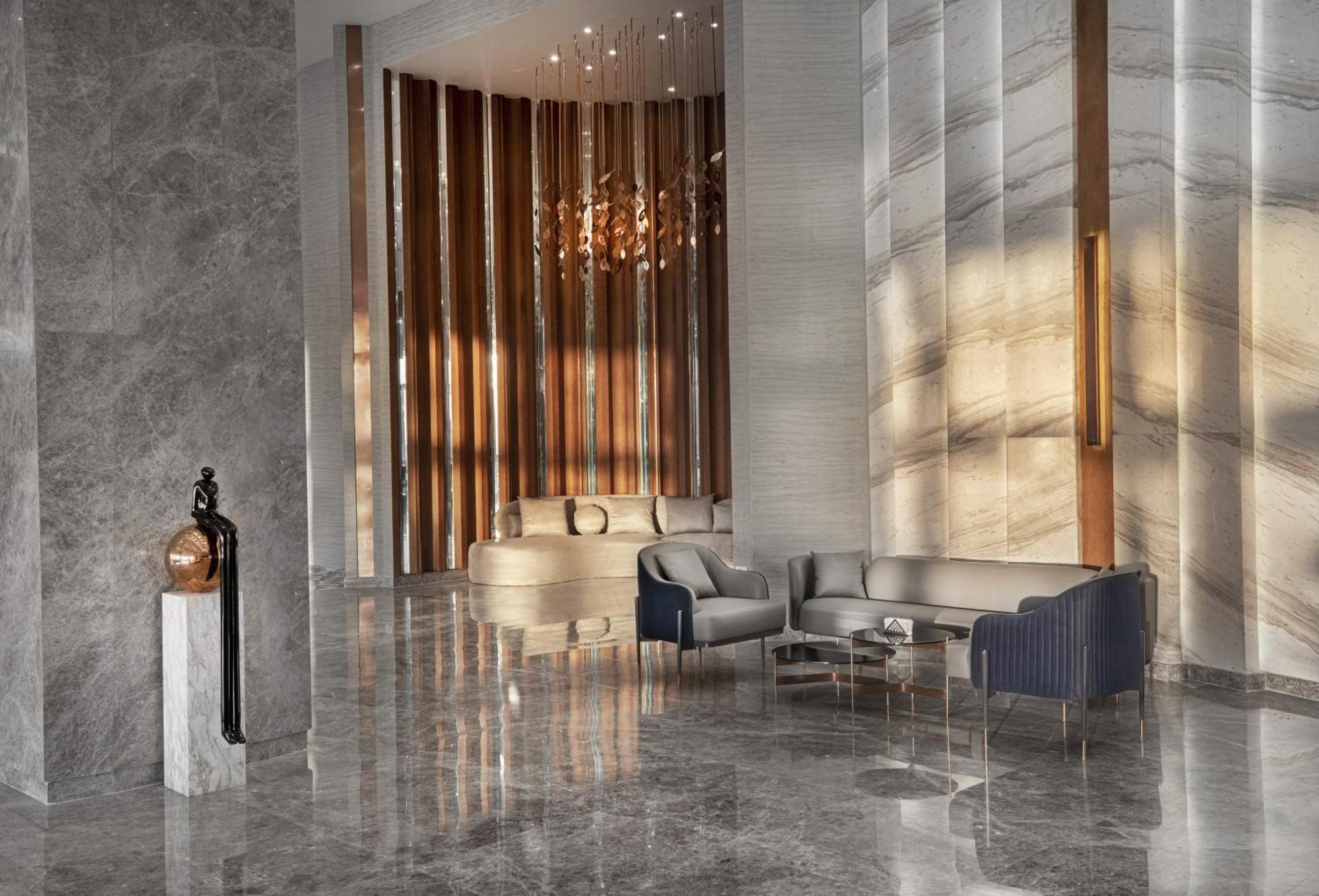 V Hotel Sharm El Shiekh Esterno foto The photo depicts a modern interior space, likely a lobby or lounge, characterized by a sleek and elegant design. The floor has a polished, reflective surface, enhancing the spaciousness of the area. 

To one side, there are vertical wooden panels th